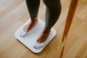 woman measuring body weight at home