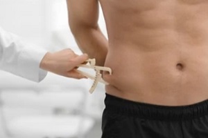 doctor measuring fat level ring around man stomach