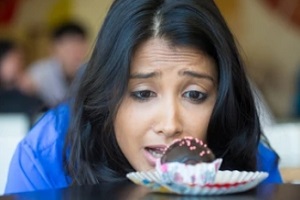 girl looking at cupcake