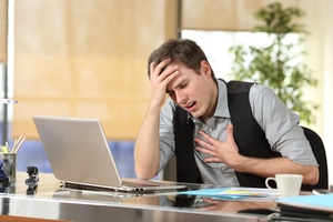 A working professional suffering from allergic asthma attack at workplace feeling uneasy breathing and holding his chest