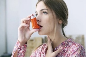 beautiful women inhaling with asthma pump