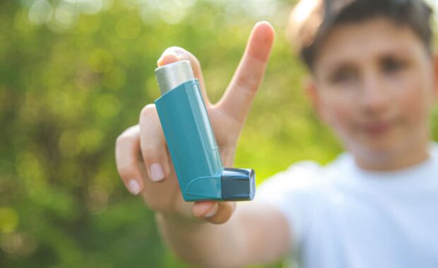 A boy showing asthma inhaler and talking about type of asthma he is suffering from