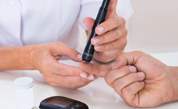 doctor measuring sugar reading of patient with glucometer