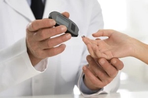 male doctor running a diabetes test on a female patient