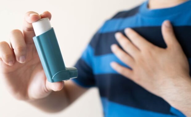 man using blue asthma inhaler for relief asthma attack