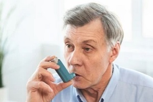 old man inhaling asthma inhaler