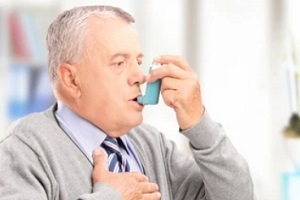 old man inhaling from asthma attack pump