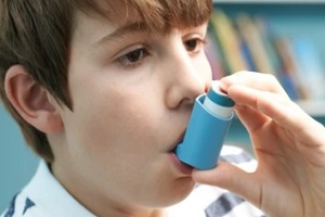 boy taking asthma inhaler after asthma attack