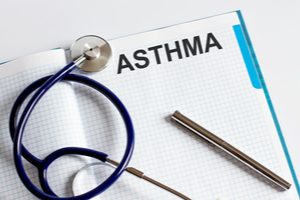A stethoscope and a pen placed on a file of an asthma management plan