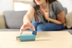 A woman is trying to grab an inhaler during an asthma attack