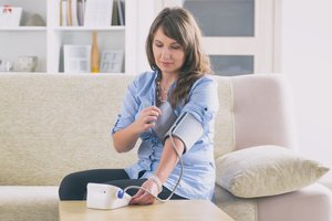 A middle-aged woman checking her blood pressure