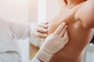 A doctor performing a breast cancer examination