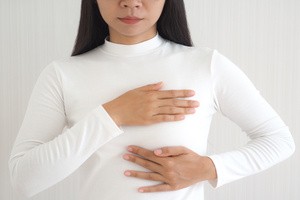 A woman checking breast for abnormal lumps