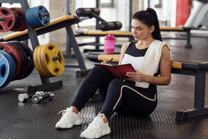 A woman making a workout plan in the gym