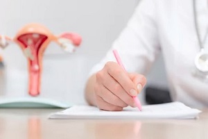 doctor writing prescription with women reproductive organ in blurry background