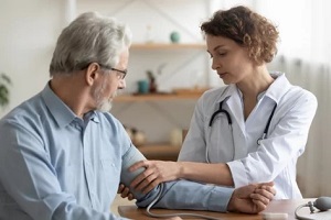 doctor checking patient blood pressure