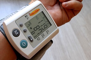 man measuring blood pressure with monitor