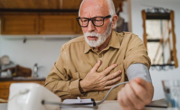 senior caucasian male use device to measure blood pressure at home