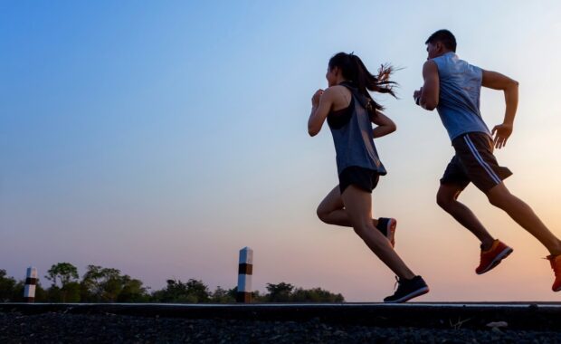 running at sunrise couple exercising for marathon and workout