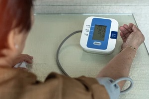 old lady measuring blood pressure with machine