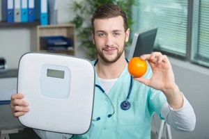 Triangle Area, NC doctor with weight machine and orange in hand