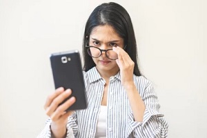 women with specs checking phone