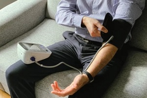 man checking blood pressure on couch