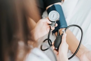  NC primary care doctor checking patient blood pressure with apparatus