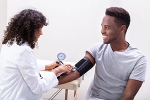 young doctor checking blood pressure
