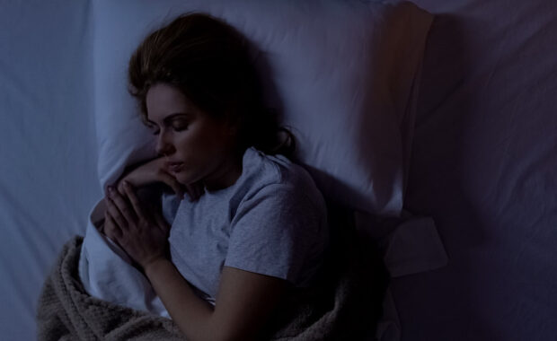 woman sleeping in comfortable bed at home