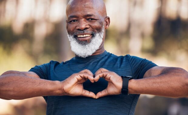 black man, fitness and heart portrait for exercise, fitness and health while outdoor in Durham, NC with a smile