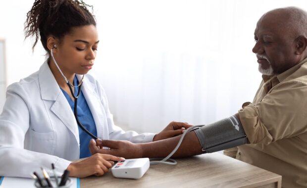 Durham family doctor checking measuring pressure on patient's hand pulse