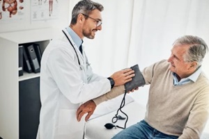 man and doctor in office for blood pressure, checkup and health advice at clinic