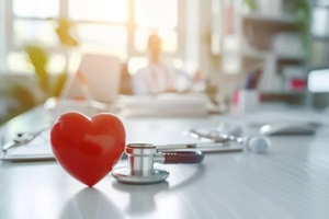 red heart love shape hand exercise ball with doctor physician's stethoscope on an office desk in Durham, NC