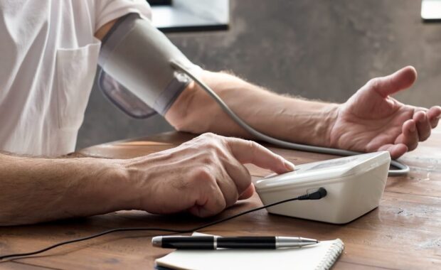 senior man using a home blood pressure machine in Raleigh, NC