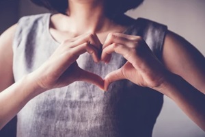 young woman making her hands in heart shape, heart health insurance, social responsibility, donation charity, world heart day, appreciation, world mental health day