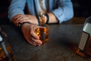 drunk man pours alcohol at the counter in bar in NC