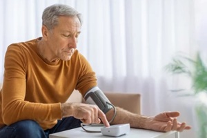 aged man checking blood pressure at home in Durham, NC