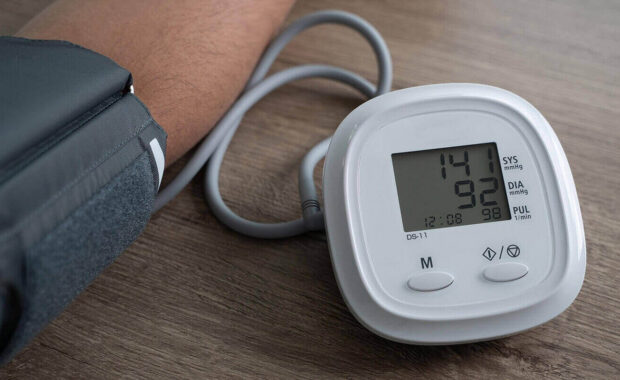 man checking blood pressure at primary care physician office in Durham, NC