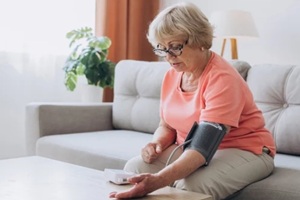 NC woman with hypertension measuring blood pressure at home