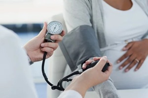 pregnant woman and doctor with appointment for blood pressure