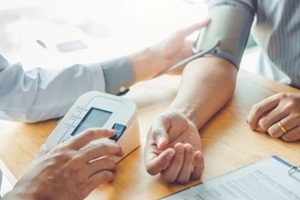 doctor checking blood pressure of a female patient