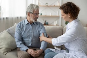 female doctor checking blood pressure of an old man