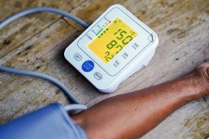 monitoring blood pressure with digital device on wooden surface