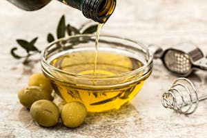 Bowl Being Poured with Olive Oil to represent health cholesterol screening fats