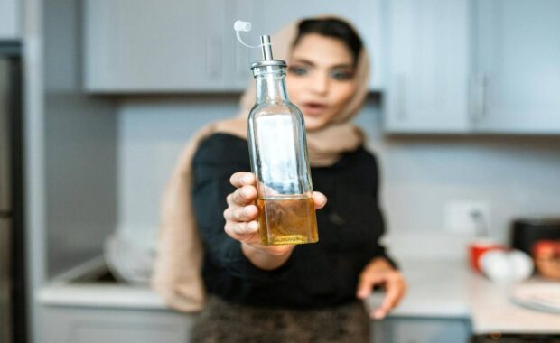 Ethnic Woman Showing Cooking Oil Bottle