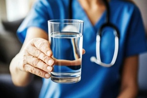 Durham, NC nurse provides hydration to senior patient in assisted living environment during rehabilitation process