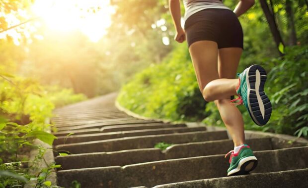 close-up of runner's legs in blue sneakers climbing outdoor stone stairs to fight pulmonary hypertension