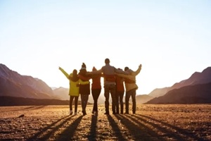 group of friends against sunset mountains