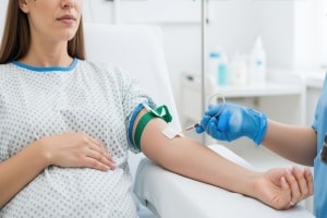 Medical Professional Taking Blood from Female Patient Arm for Cholesterol Test